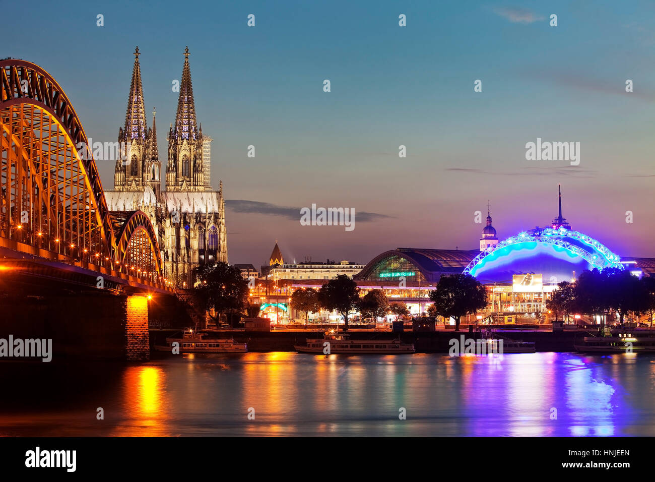Paesaggio urbano con il Reno, ponte di Hohenzollern, Duomo, la stazione centrale e il Musical Dome, crepuscolo, Colonia Foto Stock
