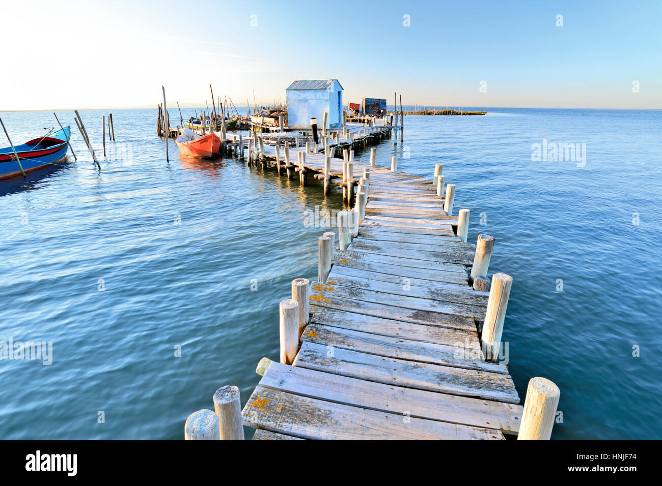 Scenic laguna con pontile in legno e le piccole barche dei pescatori. Foto Stock