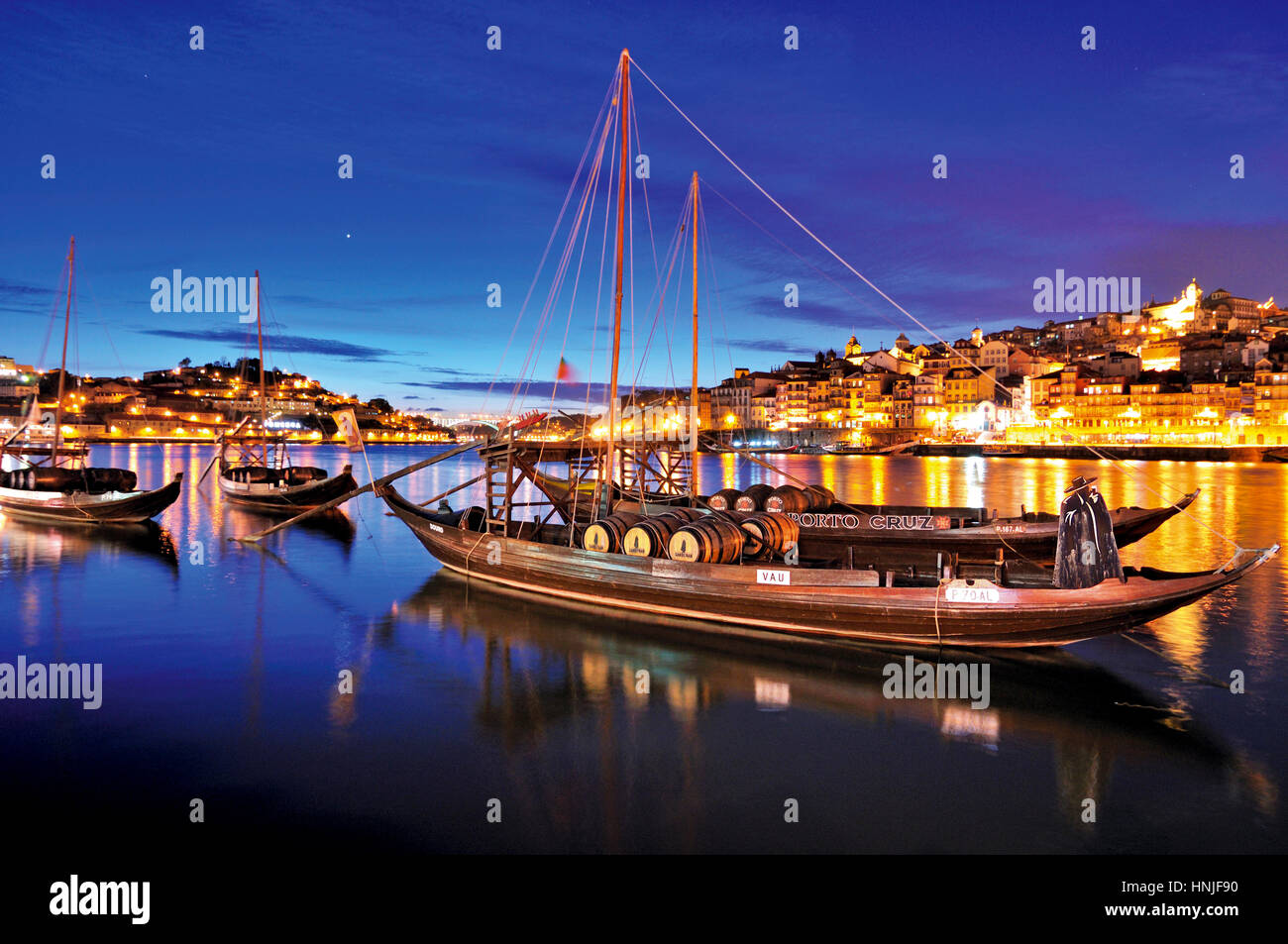 Romantica vista notturna di Oporto con Rabelo barche di ancoraggio in Vila Nova de Gaia Foto Stock