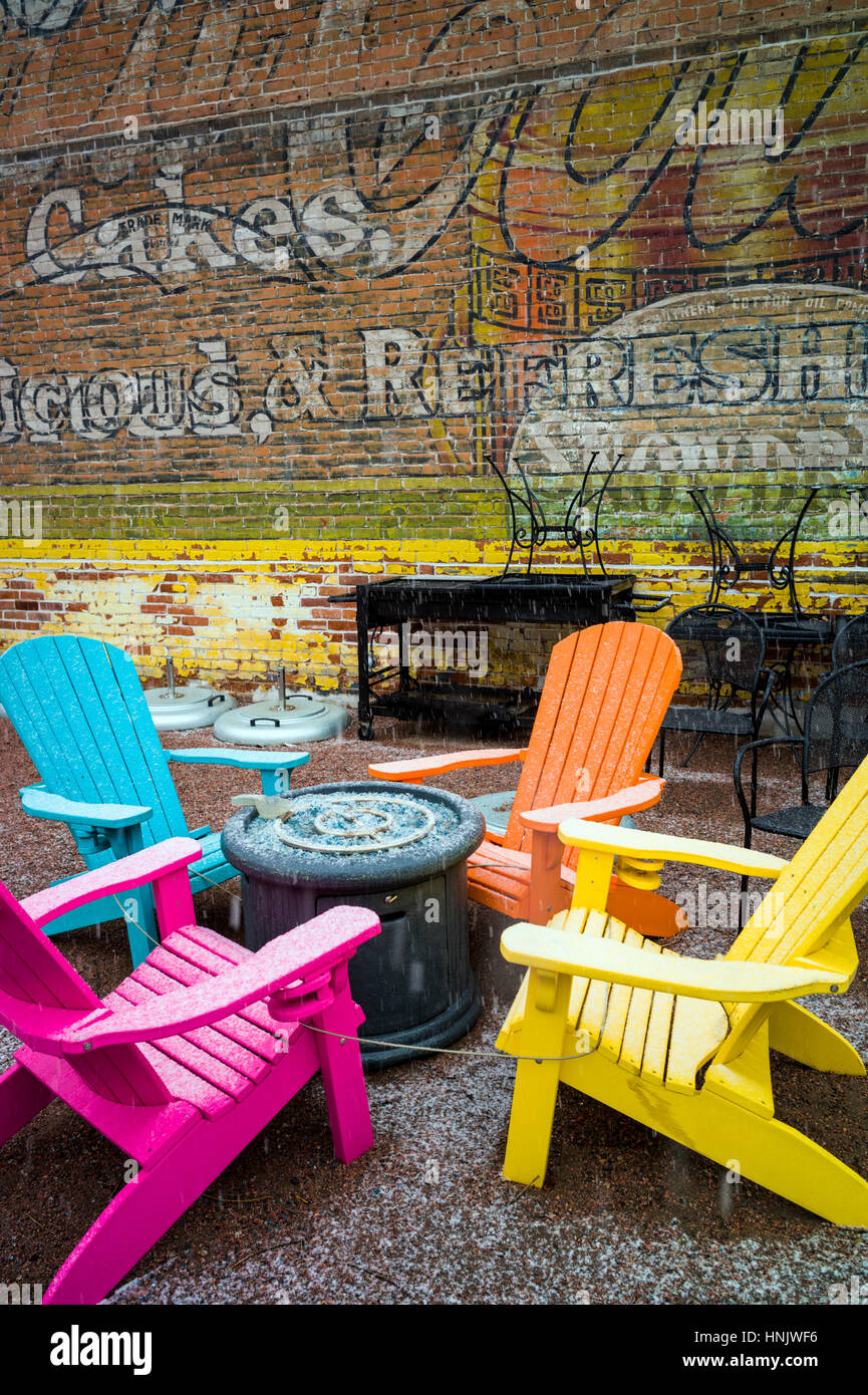 Colorate sedie per esterni e colorata carta murale in neve sul patio della Cantina Boathouse Restaurant; Salida; Colorado: STATI UNITI Foto Stock