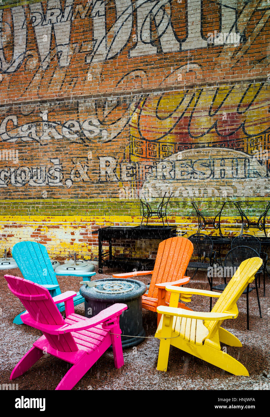 Colorate sedie per esterni e colorata carta murale in neve sul patio della Cantina Boathouse Restaurant; Salida; Colorado: STATI UNITI Foto Stock