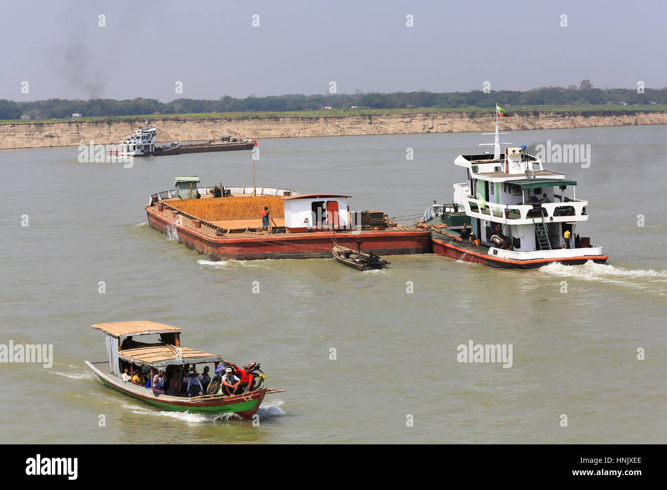 Locale di passeggeri e di traghetto di rimorchiatori e di chiatte del traffico sul fiume Irrawaddy in Myanmar (Birmania). i passeggeri del traghetto sono di scattare le foto di una crociera sul fiume in barca. Foto Stock