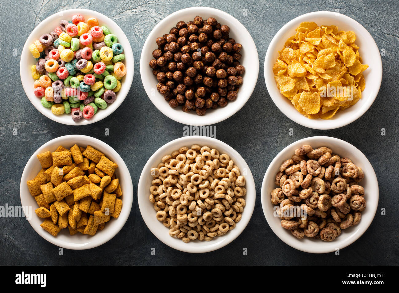 Varietà di cereali freddi in bianco bocce, veloce colazione per bambini overhead shot Foto Stock