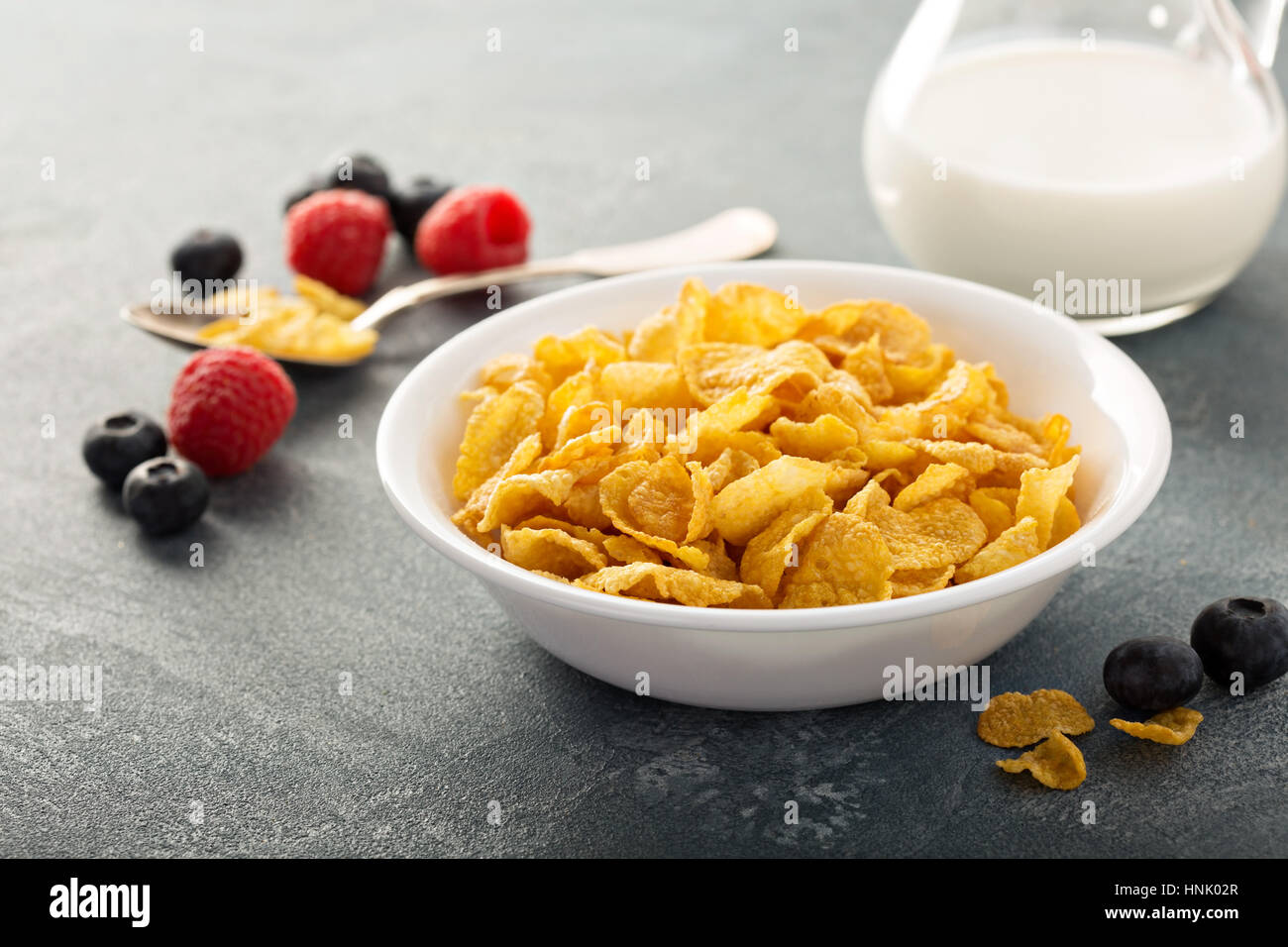 Cornflake cereali in una ciotola con il latte su sfondo blu, colazione veloce Foto Stock
