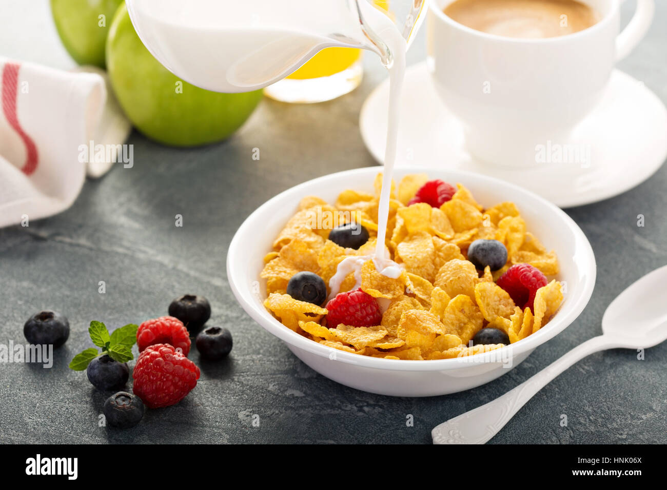Cereali Cereali con frutti di bosco e latte versando sopra Foto Stock