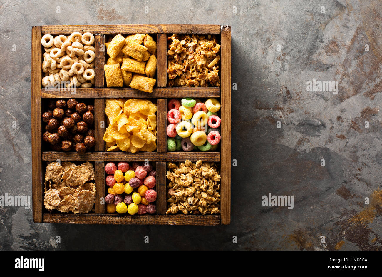 Varietà di cereali freddi in una scatola di legno, veloce colazione per bambini overhead shot Foto Stock
