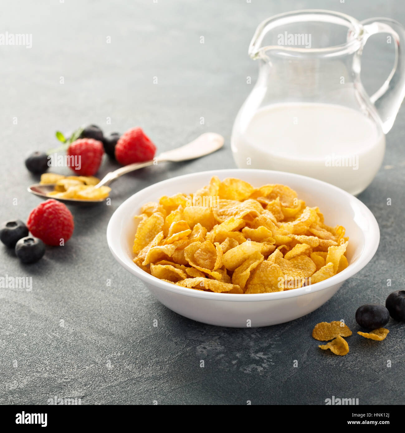 Cornflake cereali in una ciotola con il latte su sfondo blu, colazione veloce Foto Stock