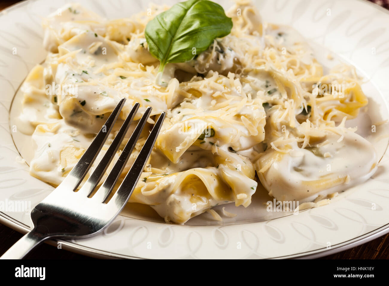 Italian tortellini in salsa alla panna con basilico e parmigiano Foto Stock