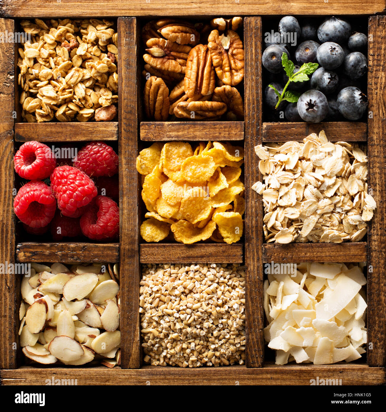 Colazione alimenti, avena, cereali e frutta in una scatola di legno overhead shot Foto Stock