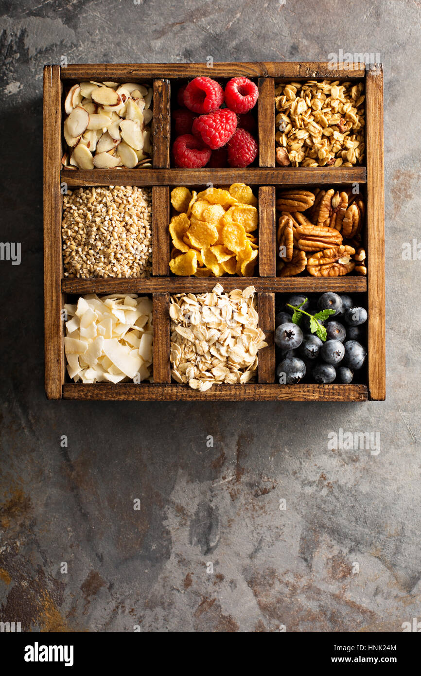 Colazione alimenti, avena, cereali e frutta in una scatola di legno overhead shot Foto Stock