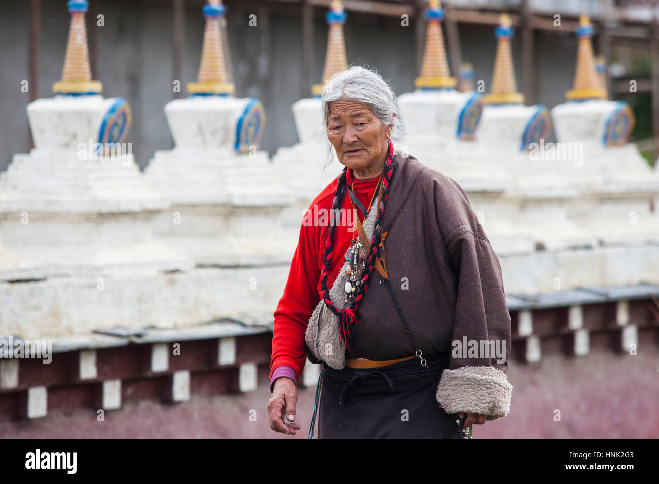 Tibetani Khampa uomini e donne pregare nel corso di una cerimonia presso il Convento delle Monache Tagong, alta nell'altopiano tibetano, Sichuan, in Cina Foto Stock