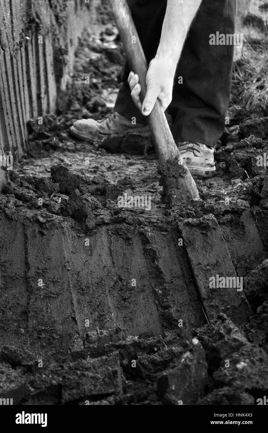 Tappeto erboso di scavo di torba a mano per il carburante a Ardara, County Donegal, Irlanda Foto Stock