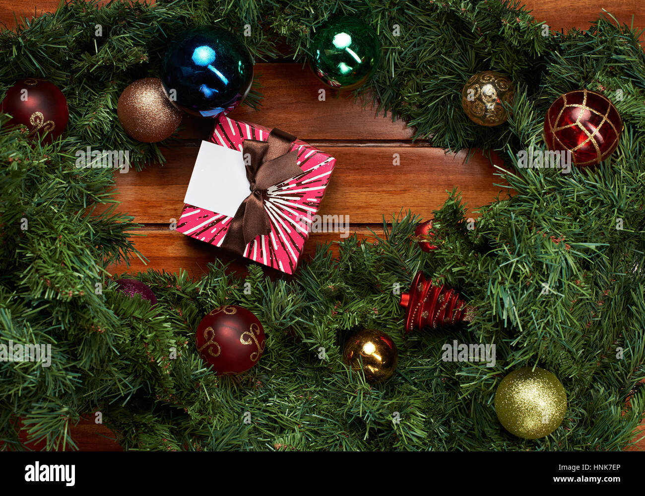 Natale regalo scatola con nastro su sfondo di legno intorno al telaio di pino Foto Stock