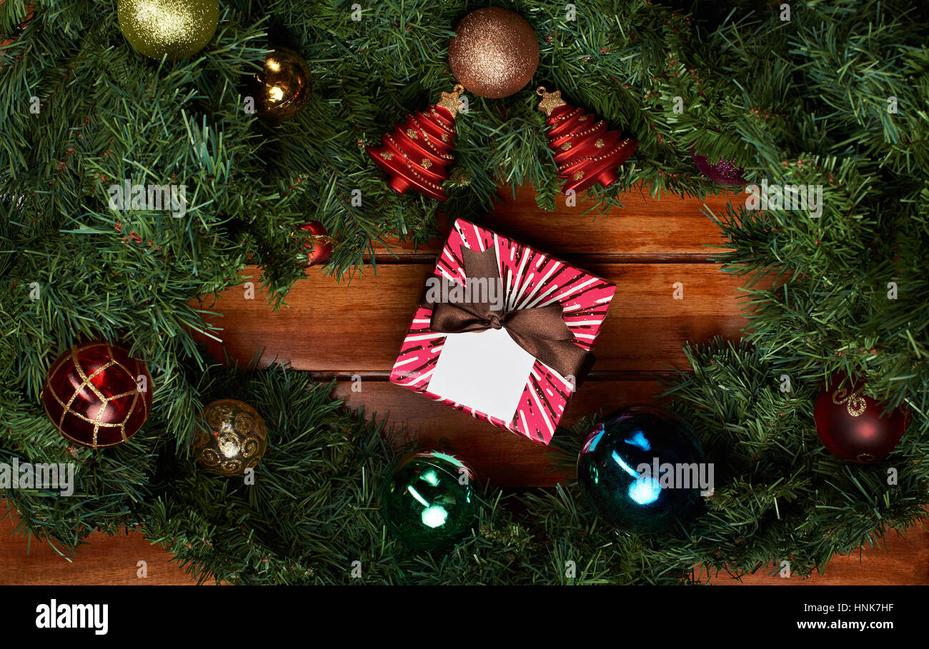 Vacanze di Natale sfondo con pini e presente box nastro su uno sfondo di legno Foto Stock