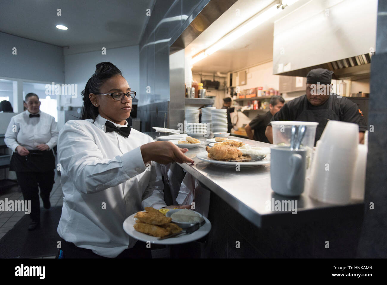 Cameriera TaShara McCray, sinistra, si prepara a prendere il cibo per i clienti a M&M Soul Food Cafe a Las Vegas Sabato, Gennaio 2, 2016. Foto Stock