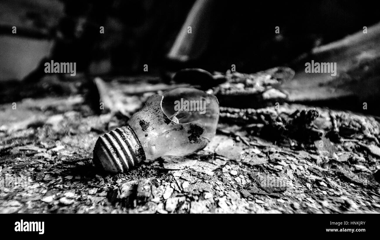 Distrutto e lampadina sporca la posa su di una superficie di bruciato. Rapporto rompere. Singola. House on fire. Foto Stock