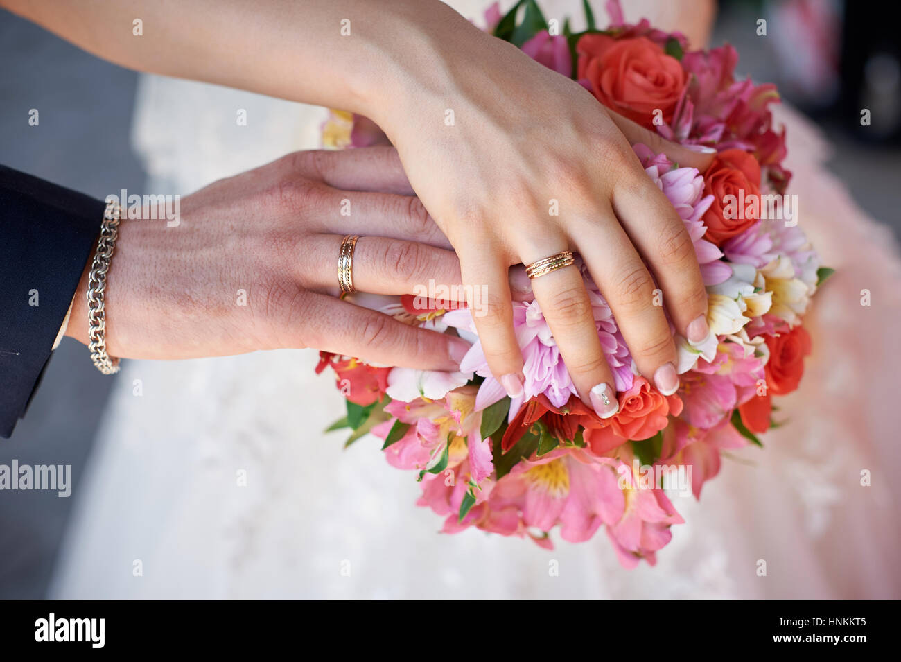 Sposa e lo sposo mano con gli anelli sul mazzo di nozze Foto Stock