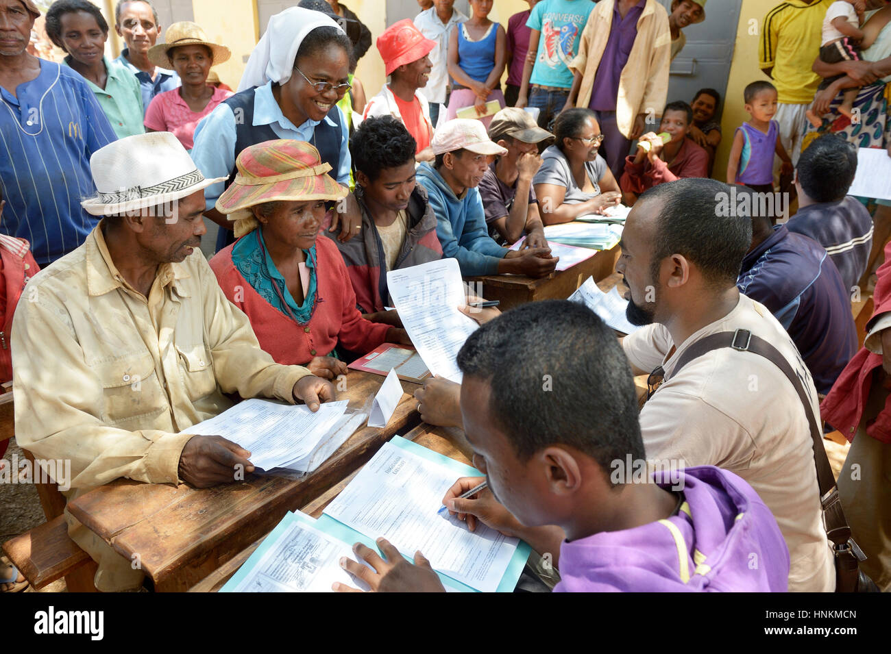 Gli abitanti di un villaggio di compilare le domande per la certificazione della loro terra sulla piazza del villaggio, Analakely village, Tanambao comune Foto Stock