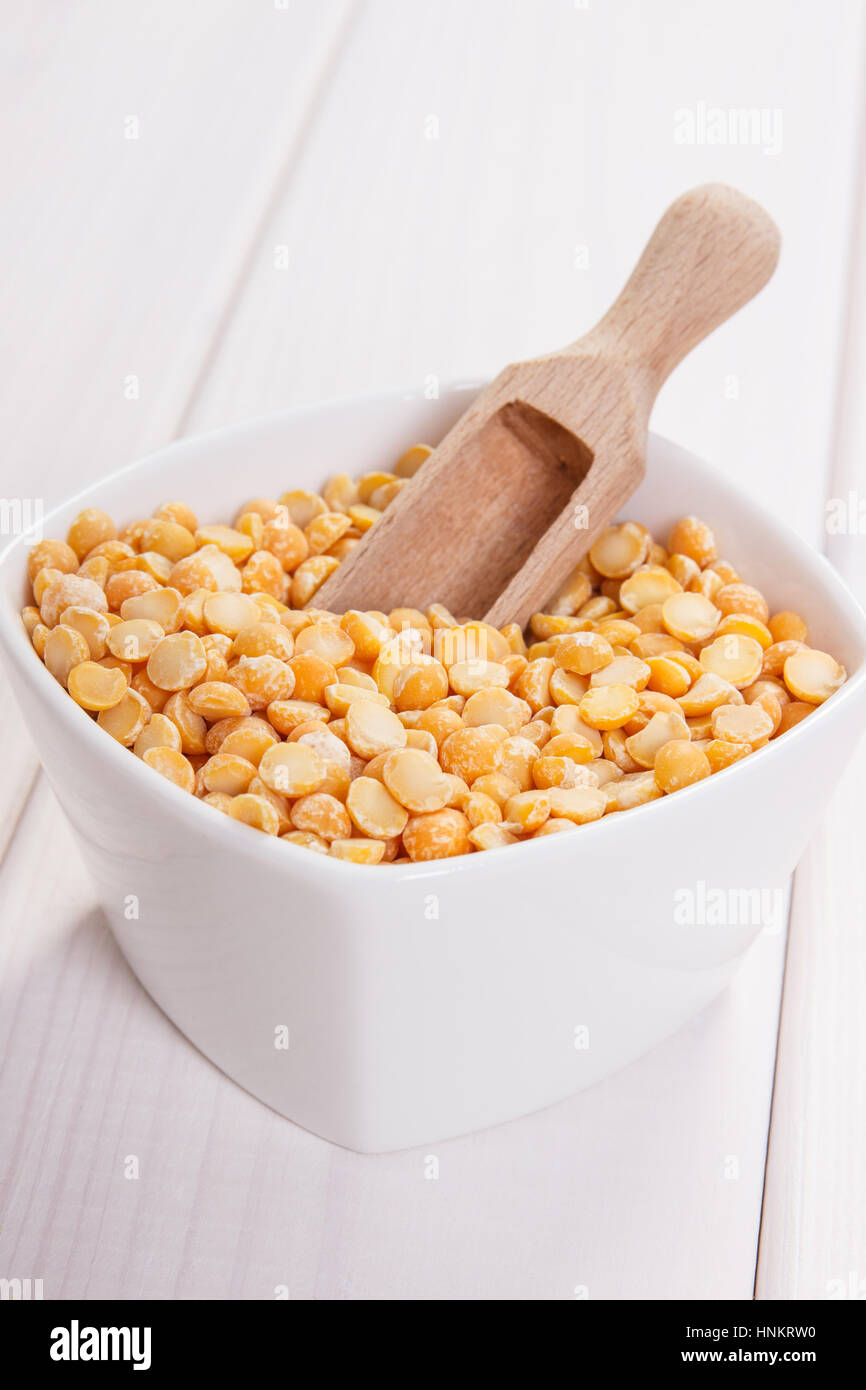 Ciotola bianco con piselli spezzati contenente zinco e fibra dietetica sulle lavagne bianche, fonti naturali di minerali, uno stile di vita sano e la nutrizione Foto Stock