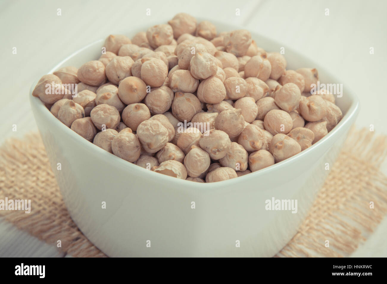 Foto d'epoca, bianco ciotola con ceci contenente zinco e fibra dietetica sulle lavagne bianche, fonti naturali di minerali, uno stile di vita sano e nutriti Foto Stock