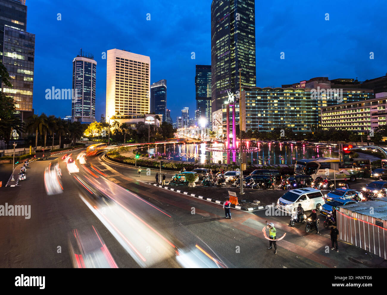 Il traffico attorno a Plaza Indonesia Jakarta nel quartiere degli affari di notte in Indonesia la città capitale. Foto Stock