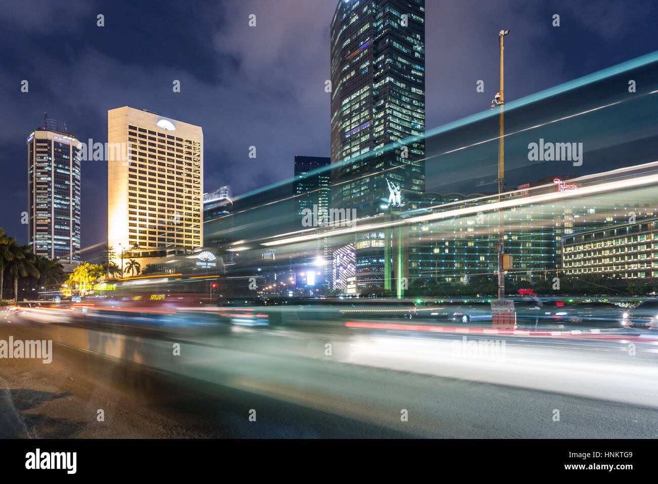 Il traffico attorno a Plaza Indonesia Jakarta nel quartiere degli affari di notte in Indonesia la città capitale. Foto Stock