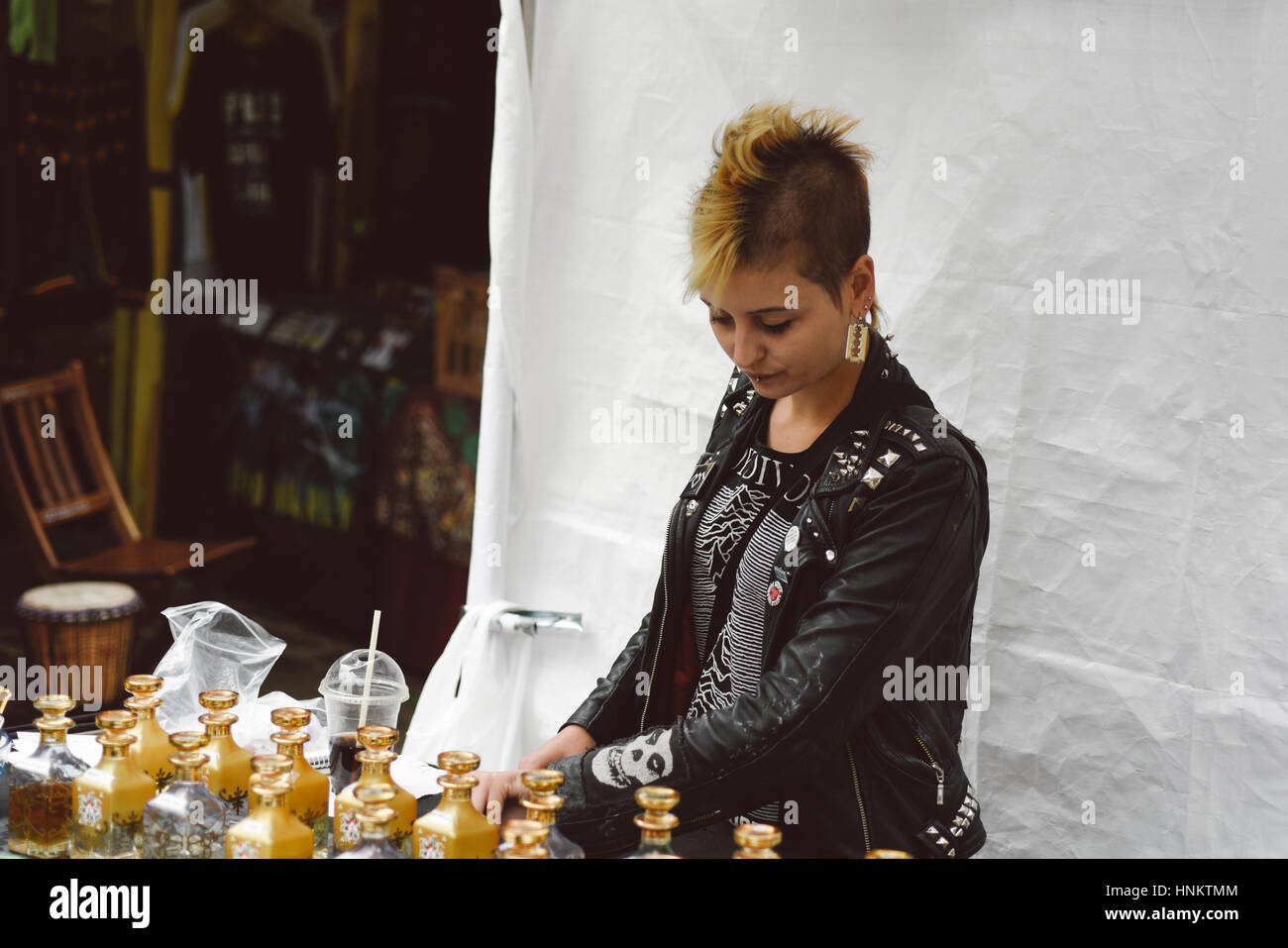 Camden moda: un punk visitatore in cerca di stallo con profumi in Camden, Londra, Regno Unito. Foto Stock