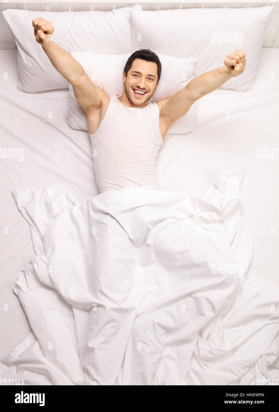 Bel ragazzo stretching se stesso nel letto Foto Stock