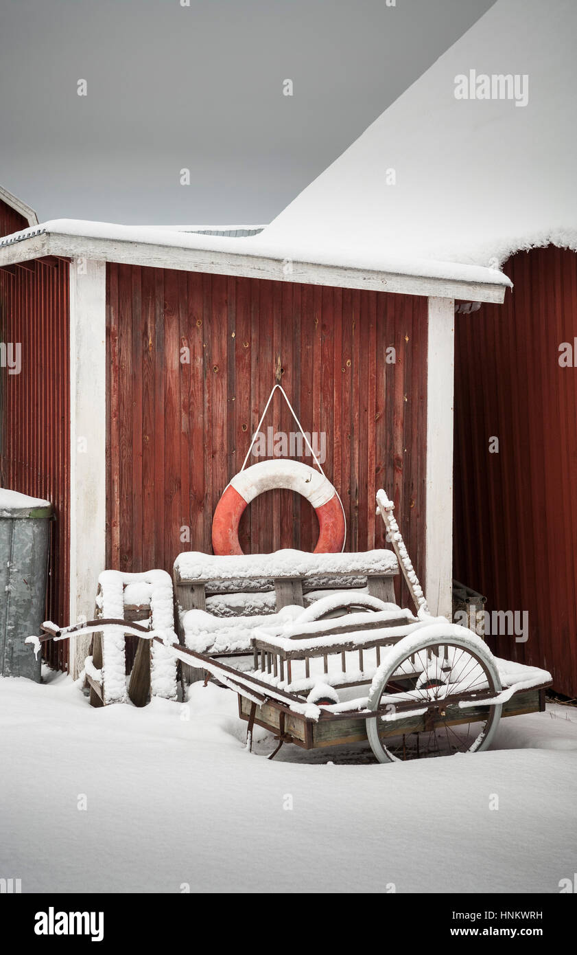 Salvagente appeso su un rosso parete in legno in inverno con la neve. Foto Stock