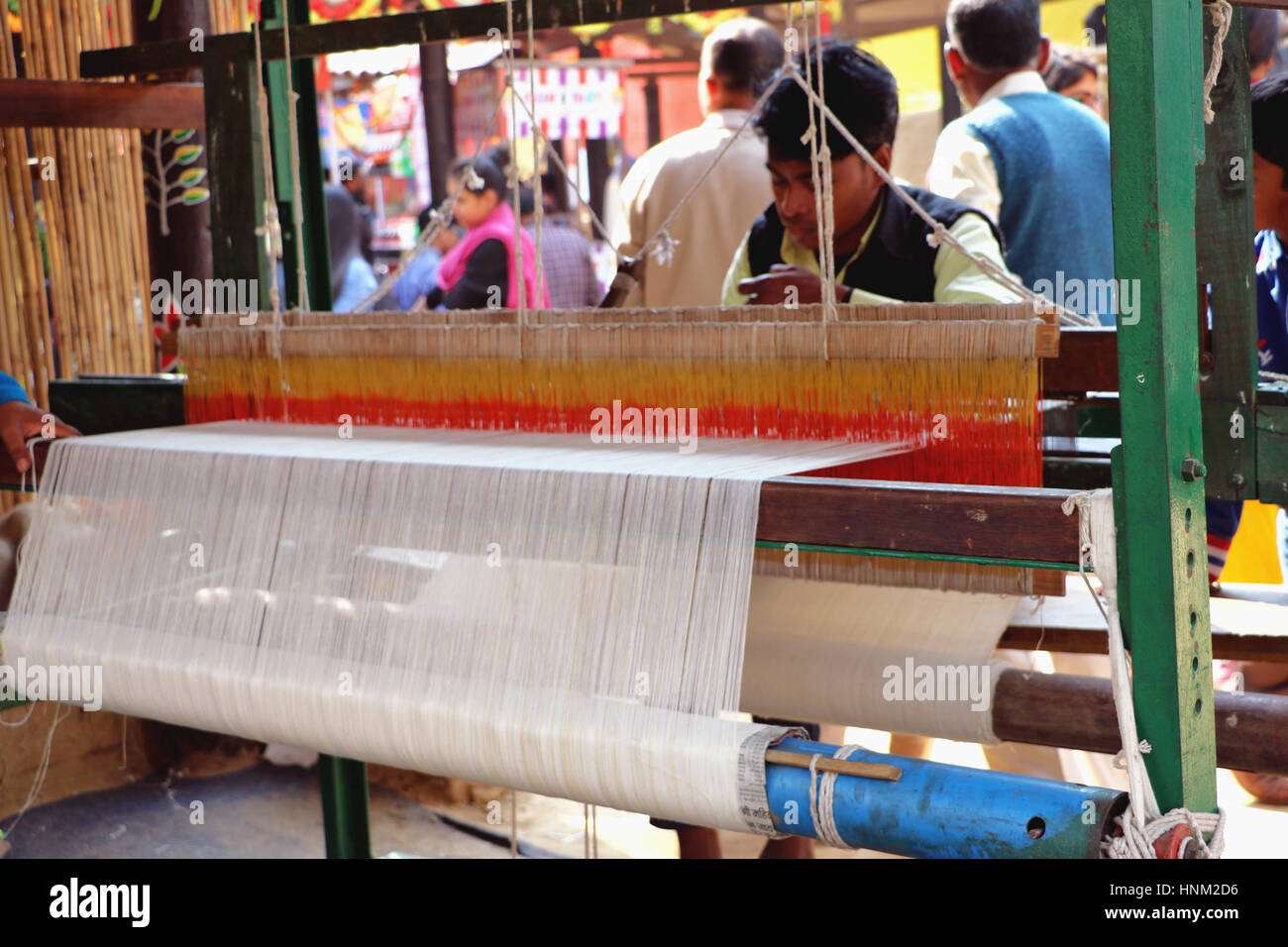 Tessitore di tessitura del tessuto su un telaio a mano in fiera surajkund. Foto Stock