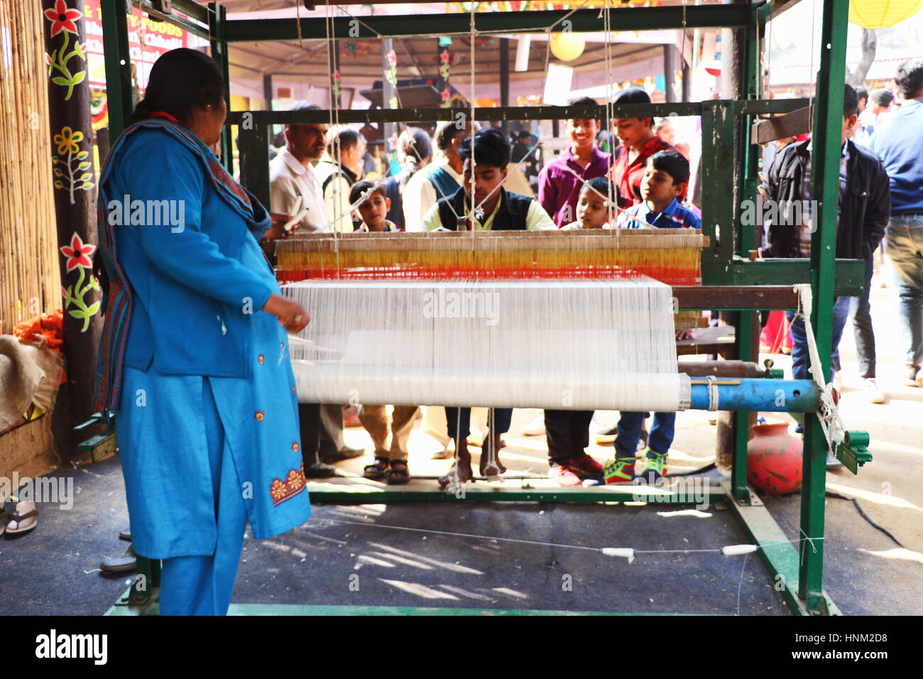 Tessitore di tessitura del tessuto su un telaio a mano in fiera surajkund. Foto Stock