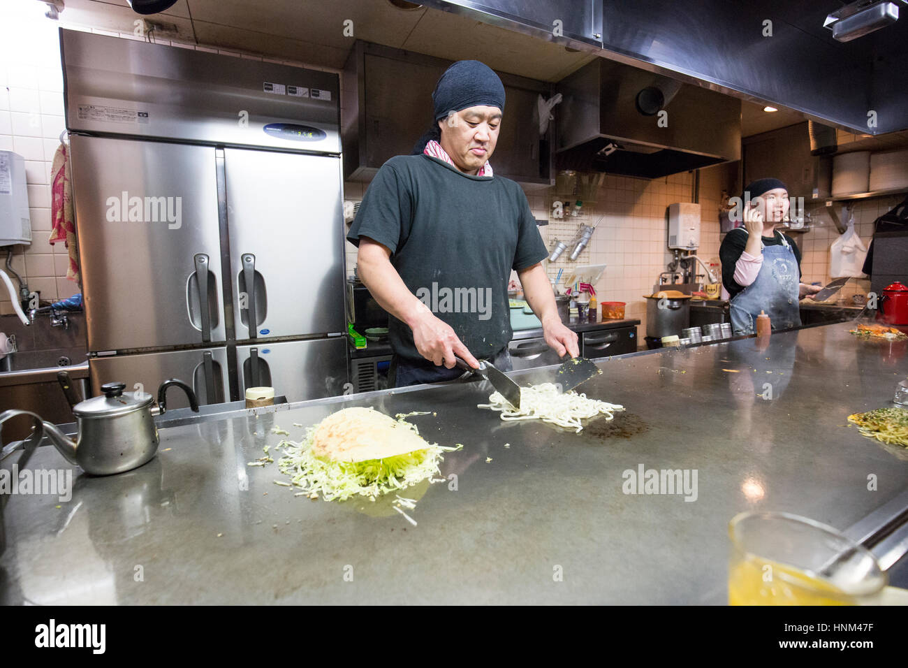 Okonomiyaki essendo preparato in un ristorante a Hiroshima, Giappone Foto Stock