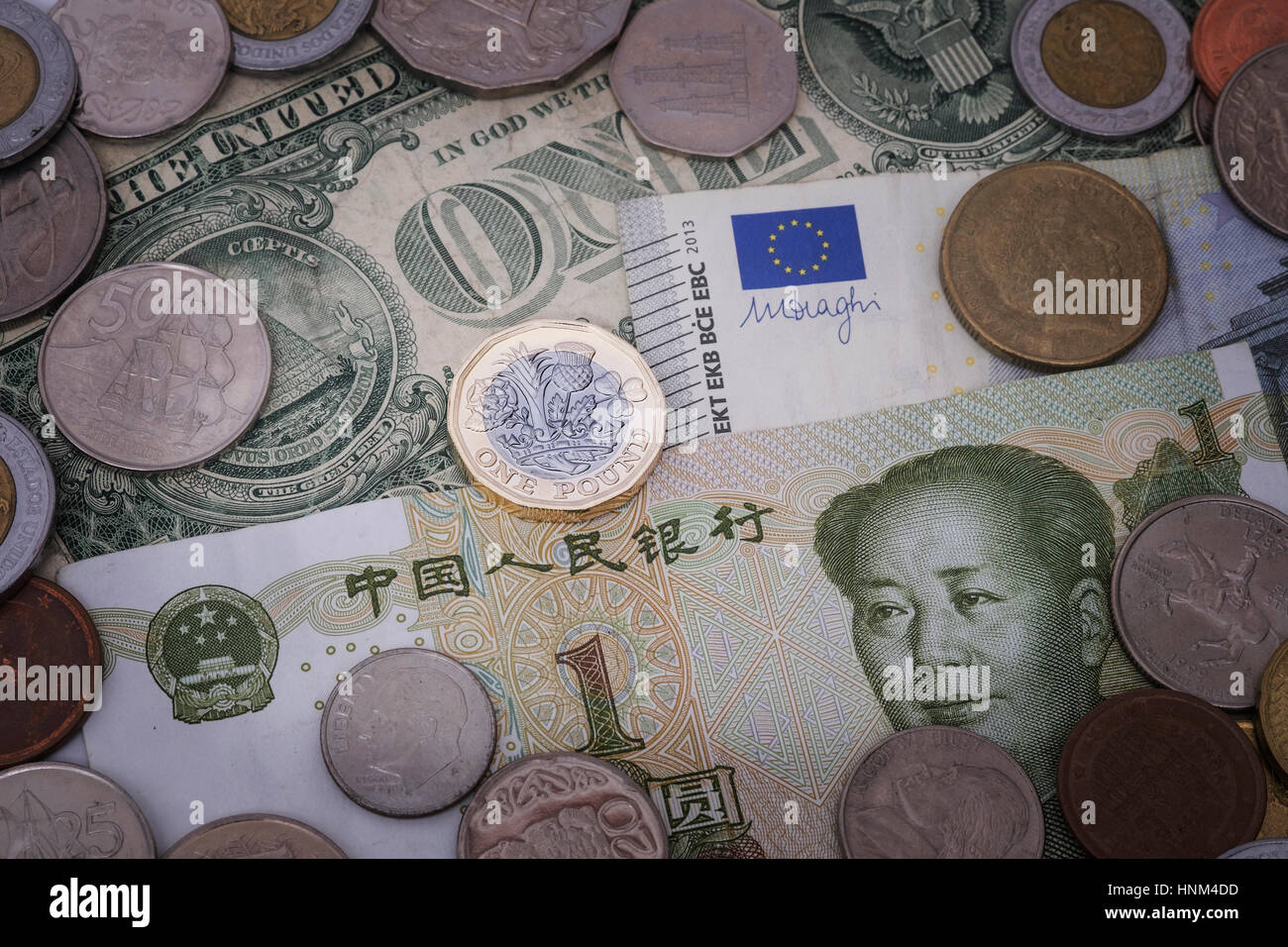British pound coin sullo sfondo delle valute comprese yuan, dollaro ed euro Foto Stock