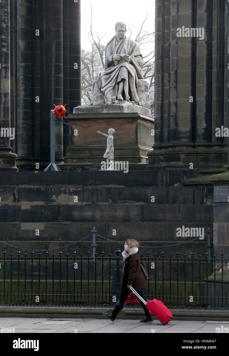 Una persona cammina passato una misteriosa scultura che è stato a sinistra al Monumento di Scott su Princes Street di Edimburgo. Foto Stock
