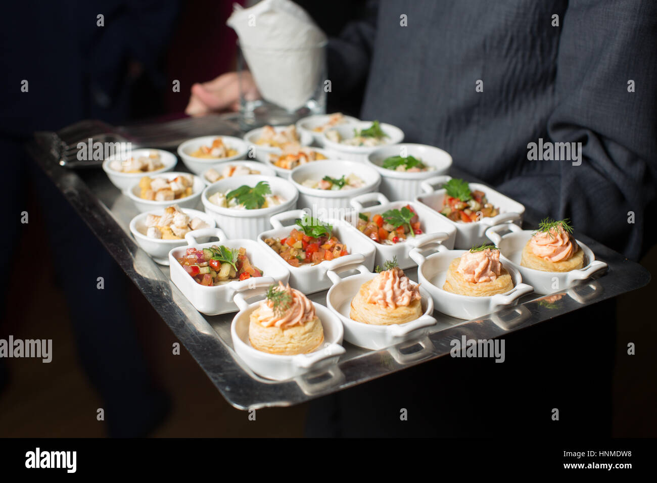 Un cameriere con un vassoio di snack a un banchetto Foto Stock