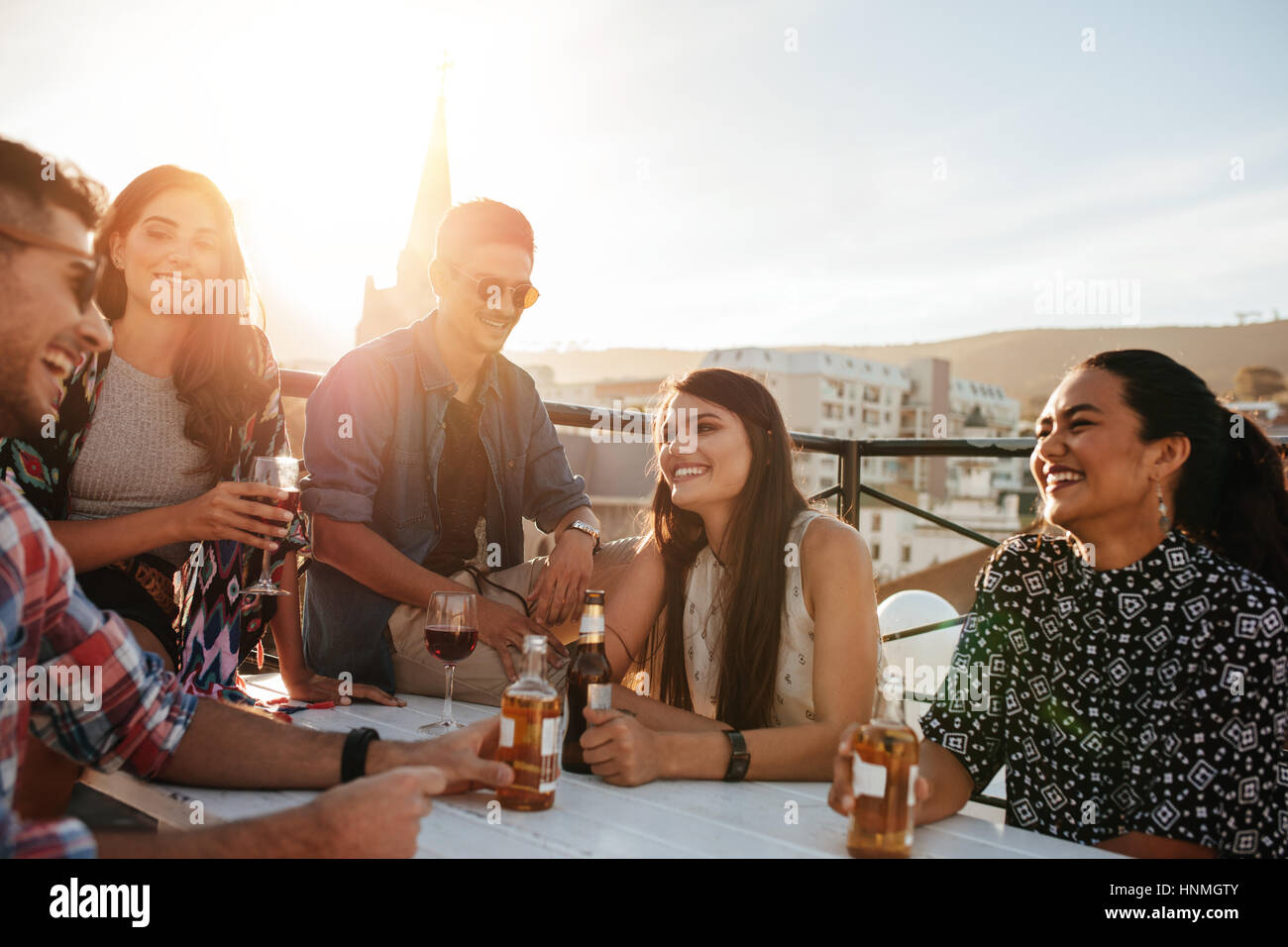 Colpo all'aperto di felice giovani avente una parte. Gli amici di ridere e godendo delle parti sul tetto. Foto Stock Colpo all'aperto di felice giovani avente una parte. Gli amici di ridere e godendo delle parti sul tetto. Foto Stock