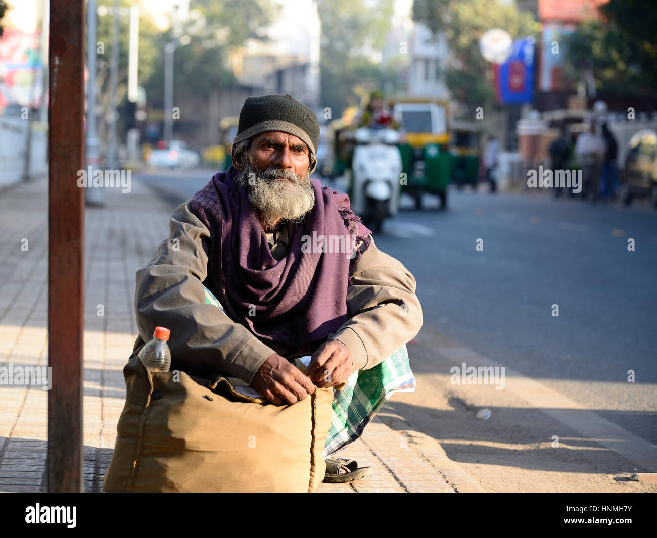 AHMADABAD, GUJARAT, INDIA - GENNAIO 30: Il povero contadino indiano aspetta l'autobus che si accosta al sacco con il riso nella città di Ahmedabad Foto Stock