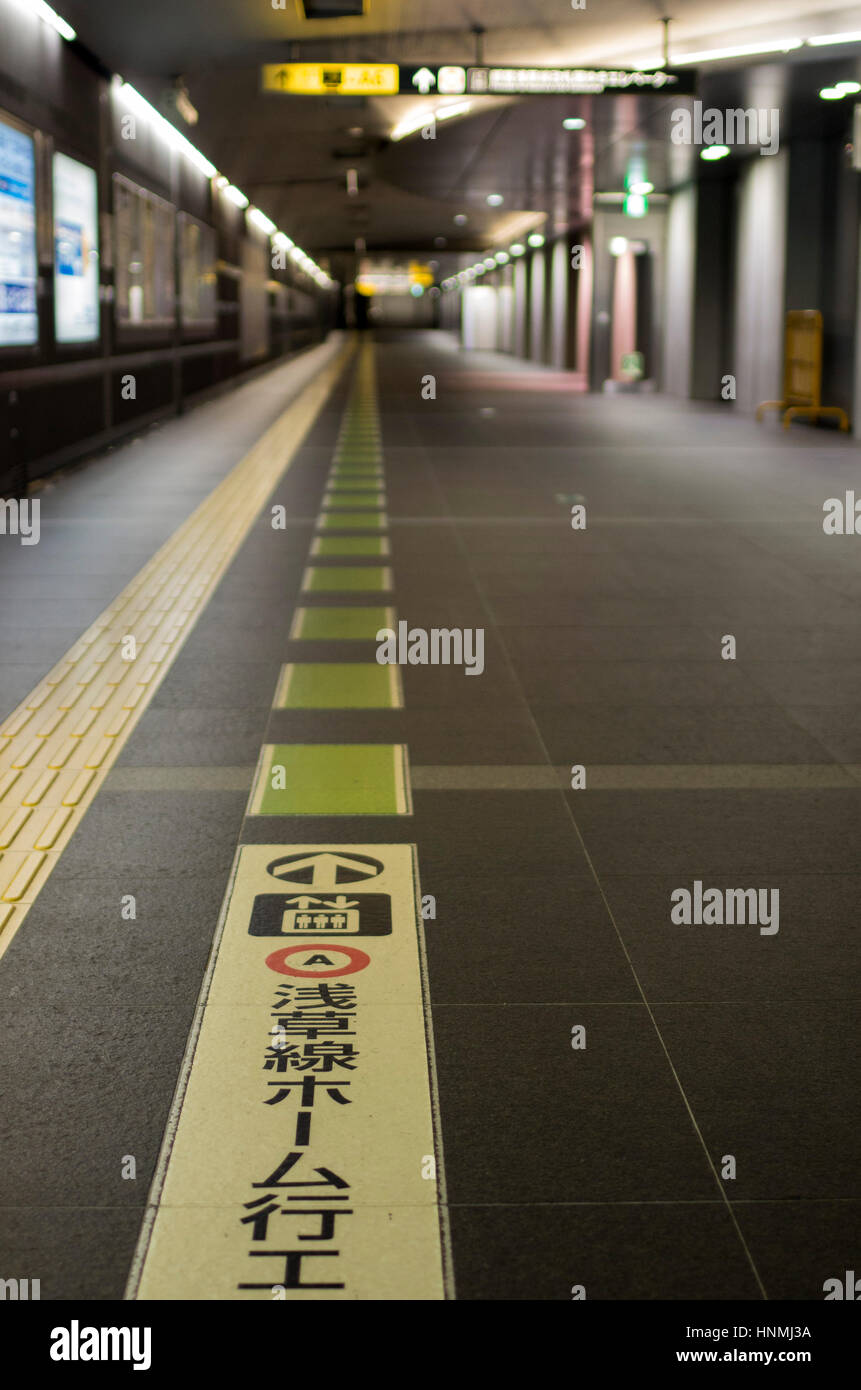 Marcatura s sul pavimento presso la stazione della metropolitana di Tokyo, Giappone. Foto Stock