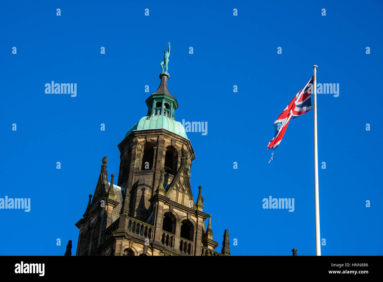 Sheffield Town Hall Tower con statua di Vulcan e Union Jack contro il cielo blu, close-up Foto Stock