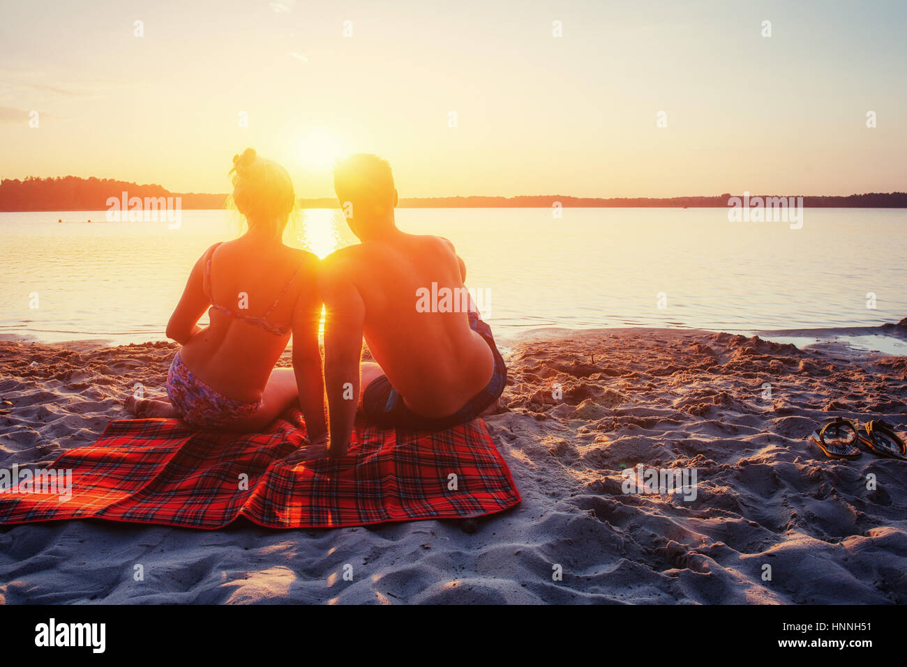 Coppia romantica sulla spiaggia al tramonto colorato Foto Stock