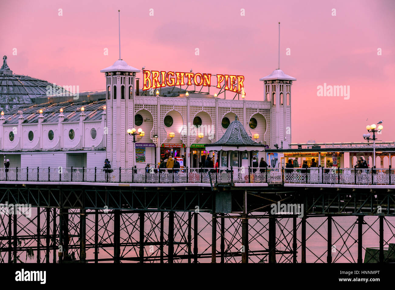Uno splendido tramonto al crepuscolo con una calda tonalità rossastra al Brighton Pier, Brighton, Inghilterra, Regno Unito Foto Stock