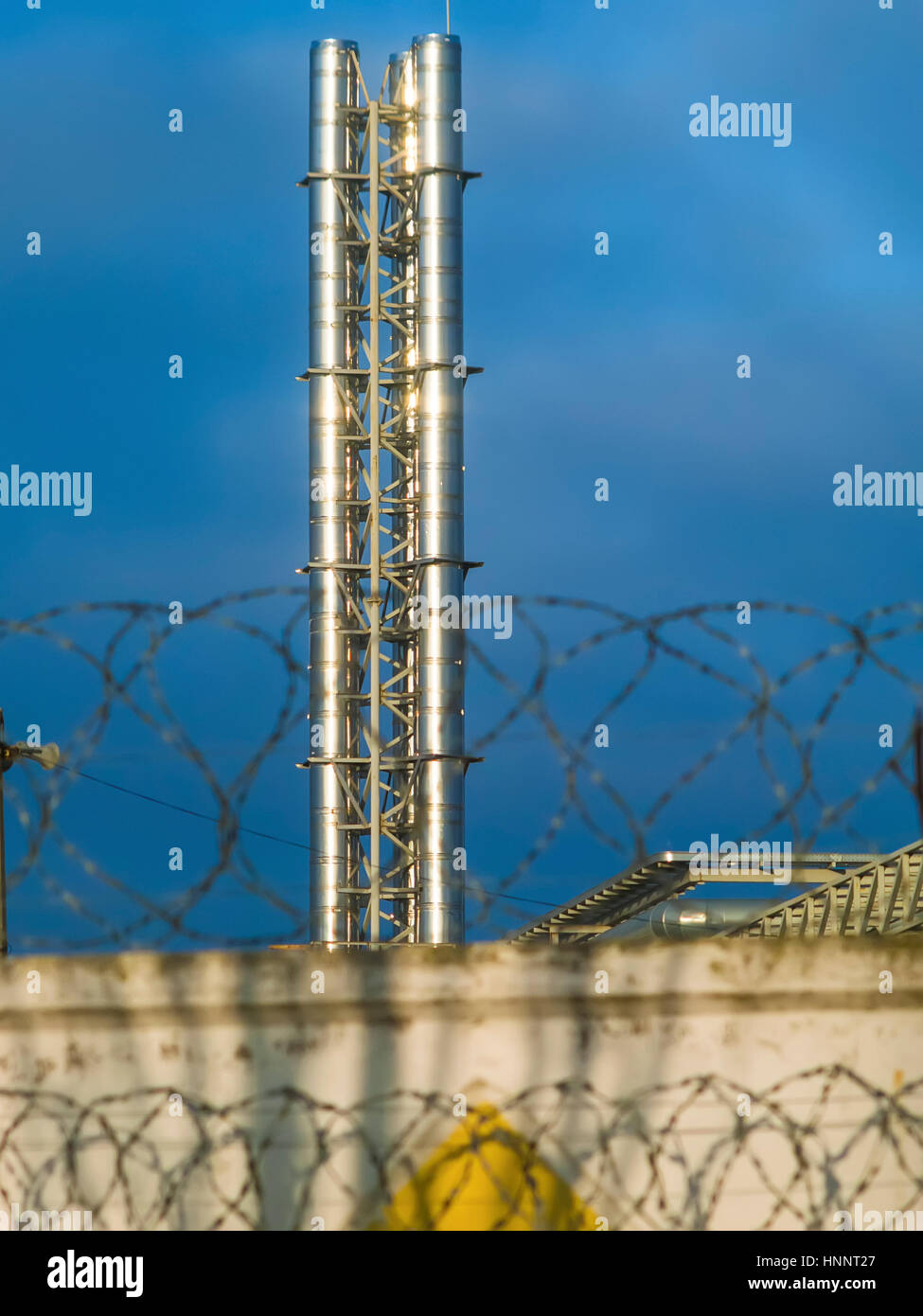 Tubo brilla al sole in fabbrica contro il cielo blu scuro Foto Stock