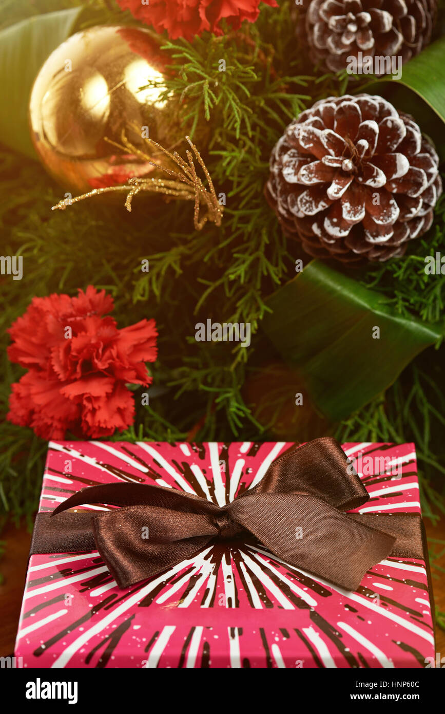 Nastro marrone sulla colorata confezione regalo con decorazione di Natale pigna Foto Stock