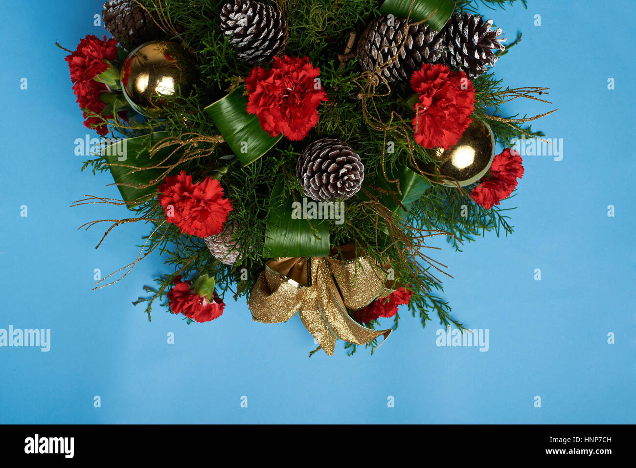 Nuovo Anno decorazioni di pino con fiore e cono isolato su sfondo blu Foto Stock