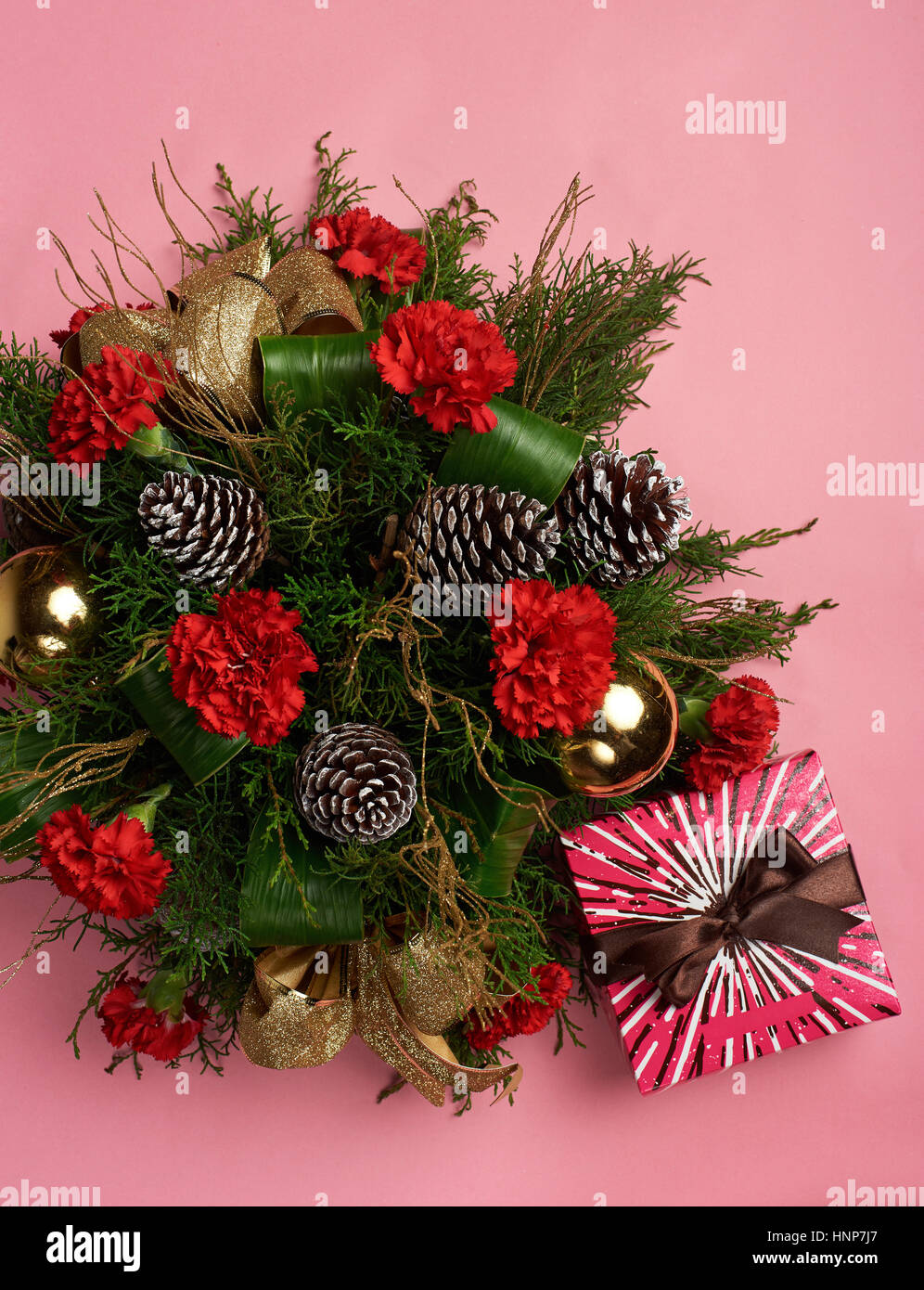 Pino decorazione di Natale su sfondo rosa con confezione regalo e nastro marrone Foto Stock