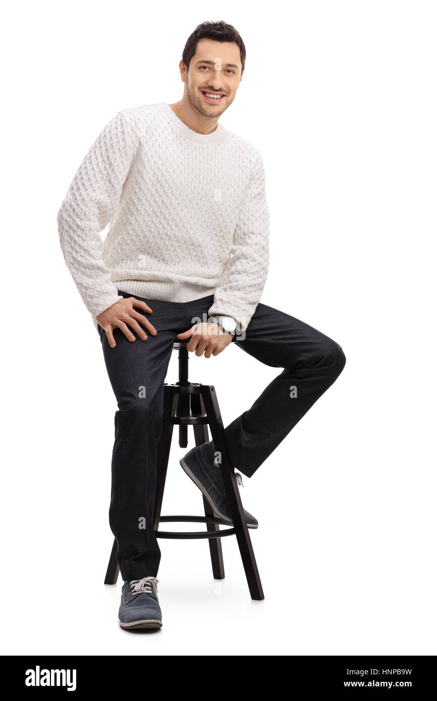 Giovane ragazzo seduto su una sedia sorridente e guardando la telecamera isolata su sfondo bianco Foto Stock