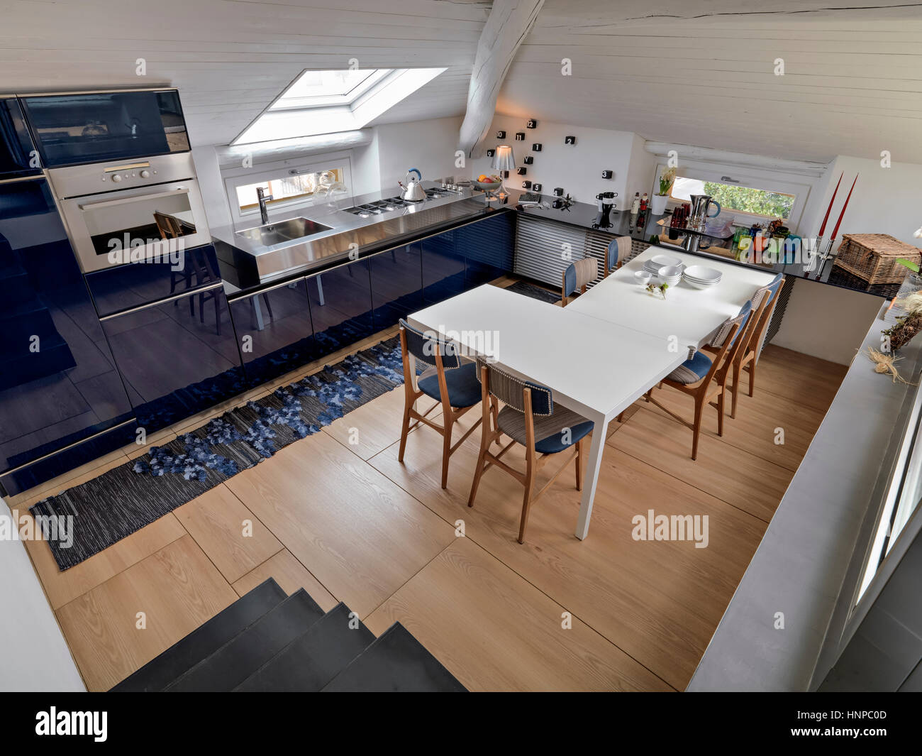 Nteriore vista di una moderna cucina con tavolo da pranzo in soffitta romm il cui pavimento è fatto di legno Foto Stock