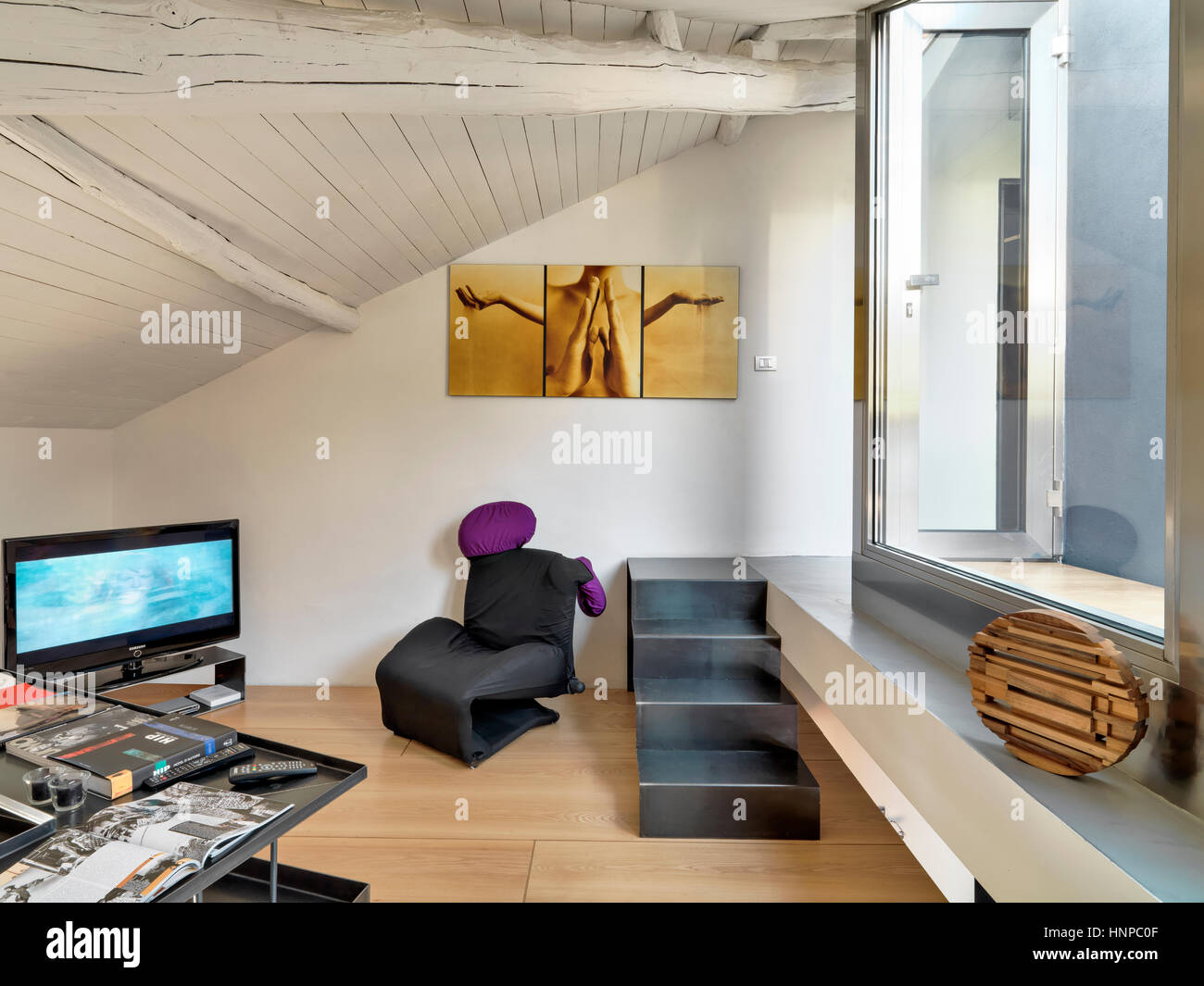 Vista interna di un moderno soggiorno in mansarda con pavimento in legno e il soffitto di legno Foto Stock