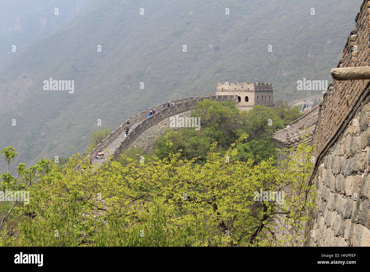 La Grande Muraglia della Cina al Mutyanu. Mountanious paesaggio con lo smog da Pechino in background Foto Stock