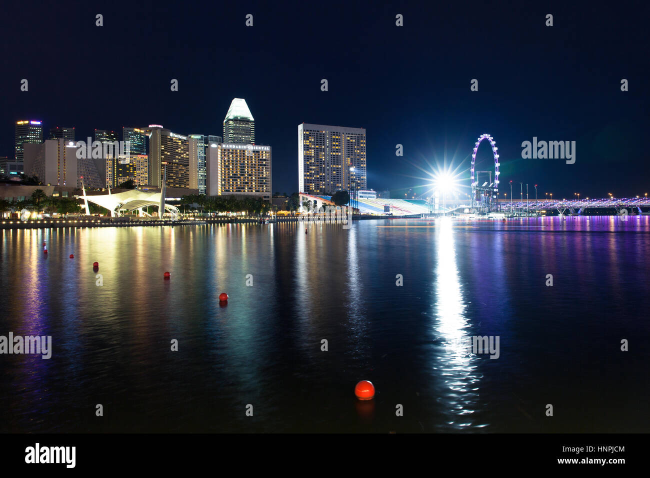 Lo skyline di Singapore, Singapore Flyer e Marina nelle acque della baia di notte al 15 luglio 2013. Foto Stock